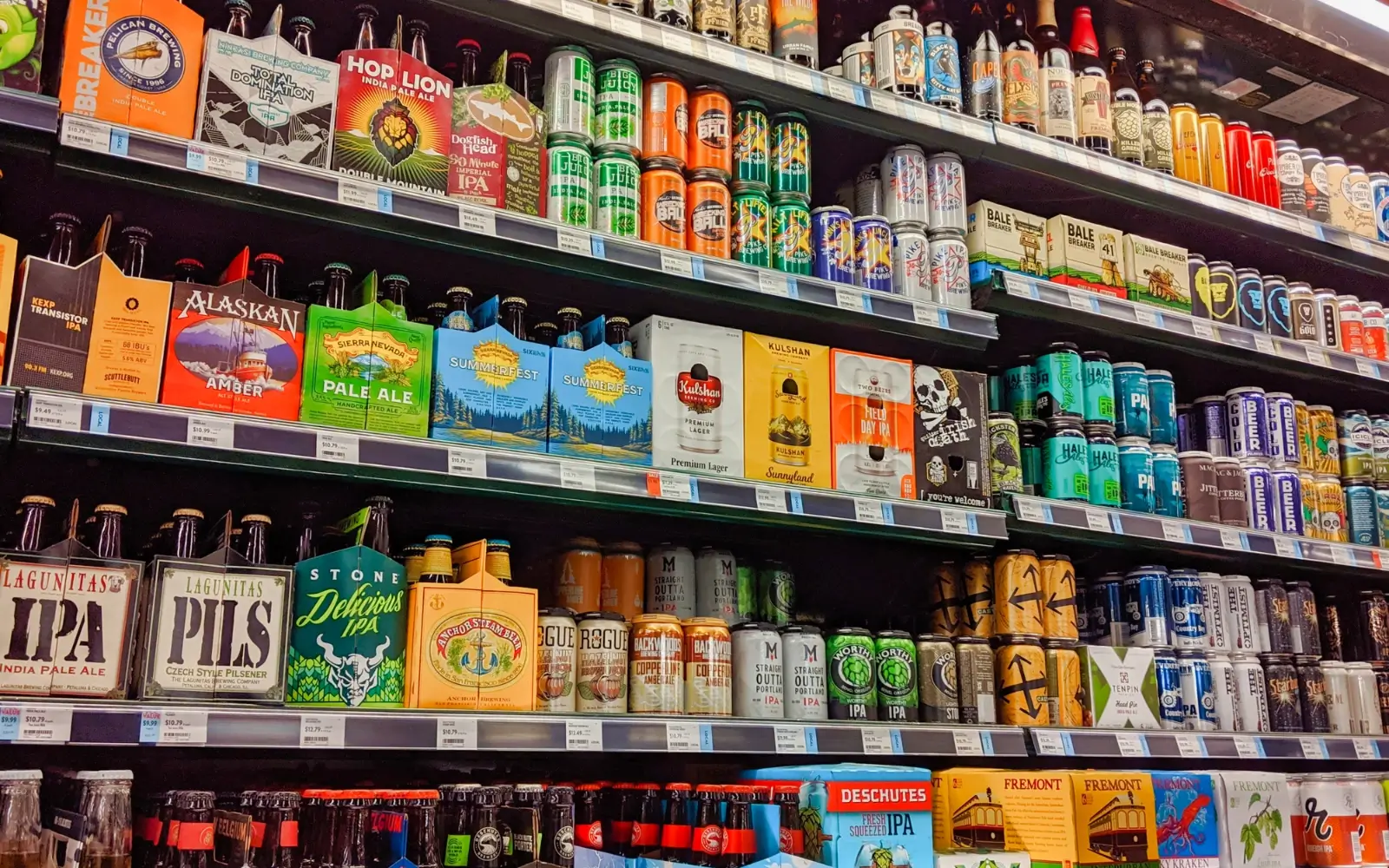 Rows of beers and brewery labels on store shelves